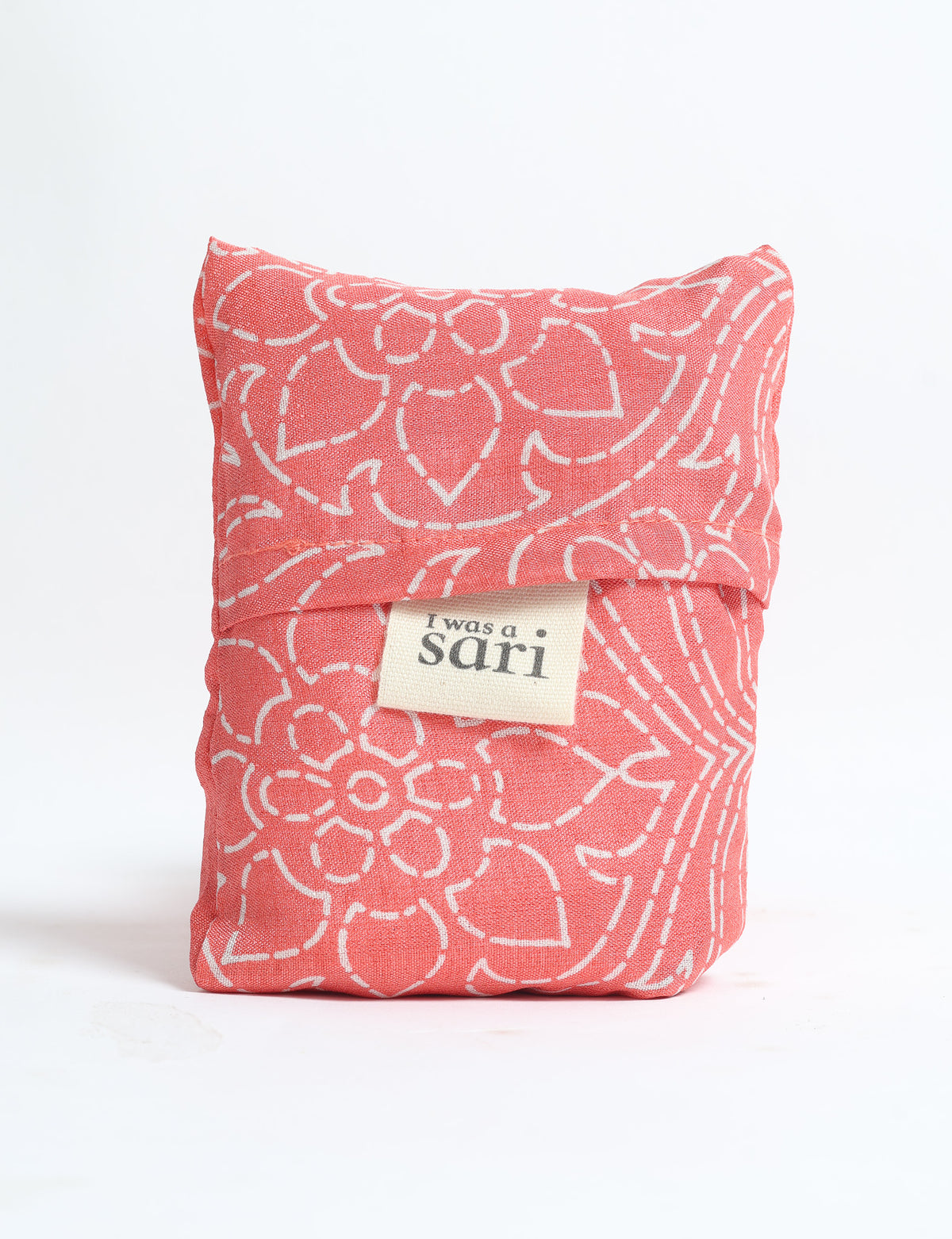 Pink reusable bag with white floral pattern folded, featuring a label that reads "I was a sari" on front