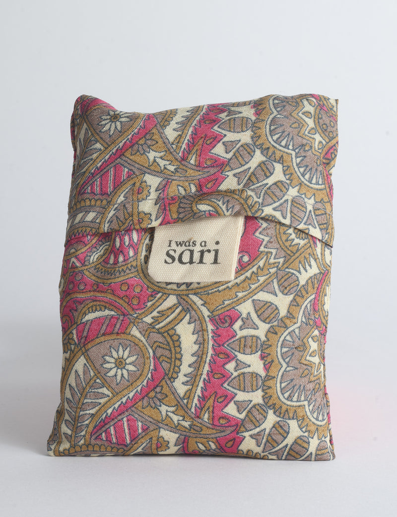 Blue reusable bag with multicolor tropical floral pattern folded with "I was a sari" label visible on front