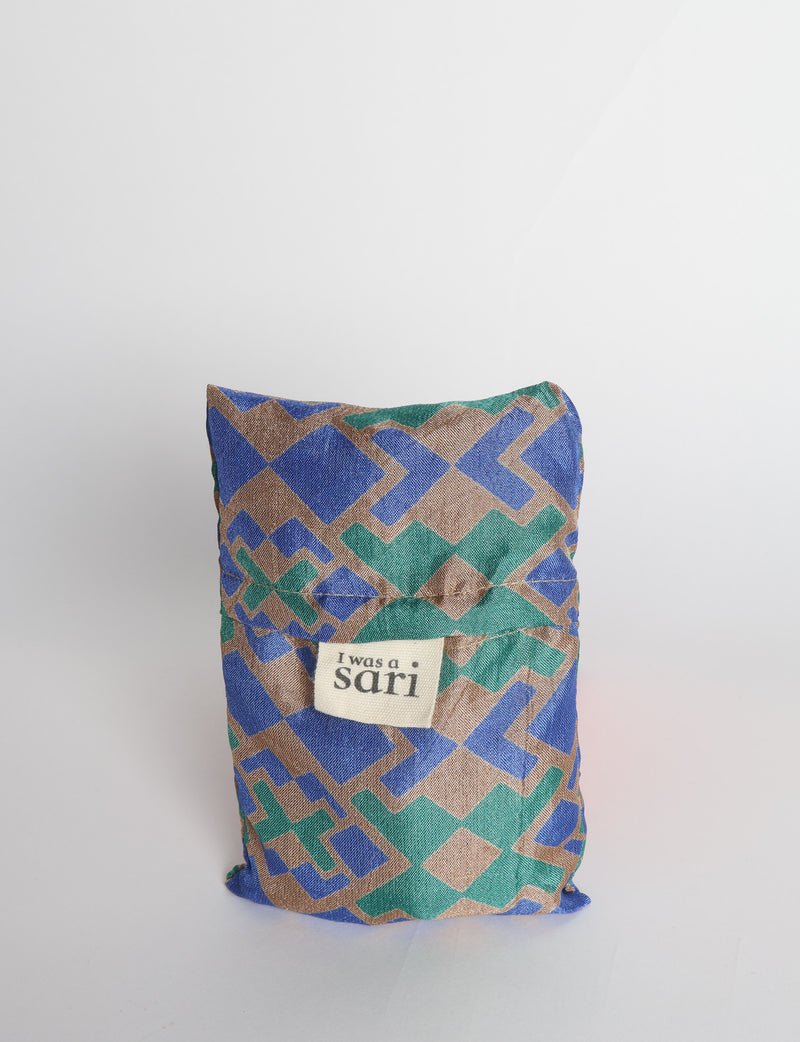 Blue reusable bag with multicolor tropical floral pattern folded with "I was a sari" label visible on front