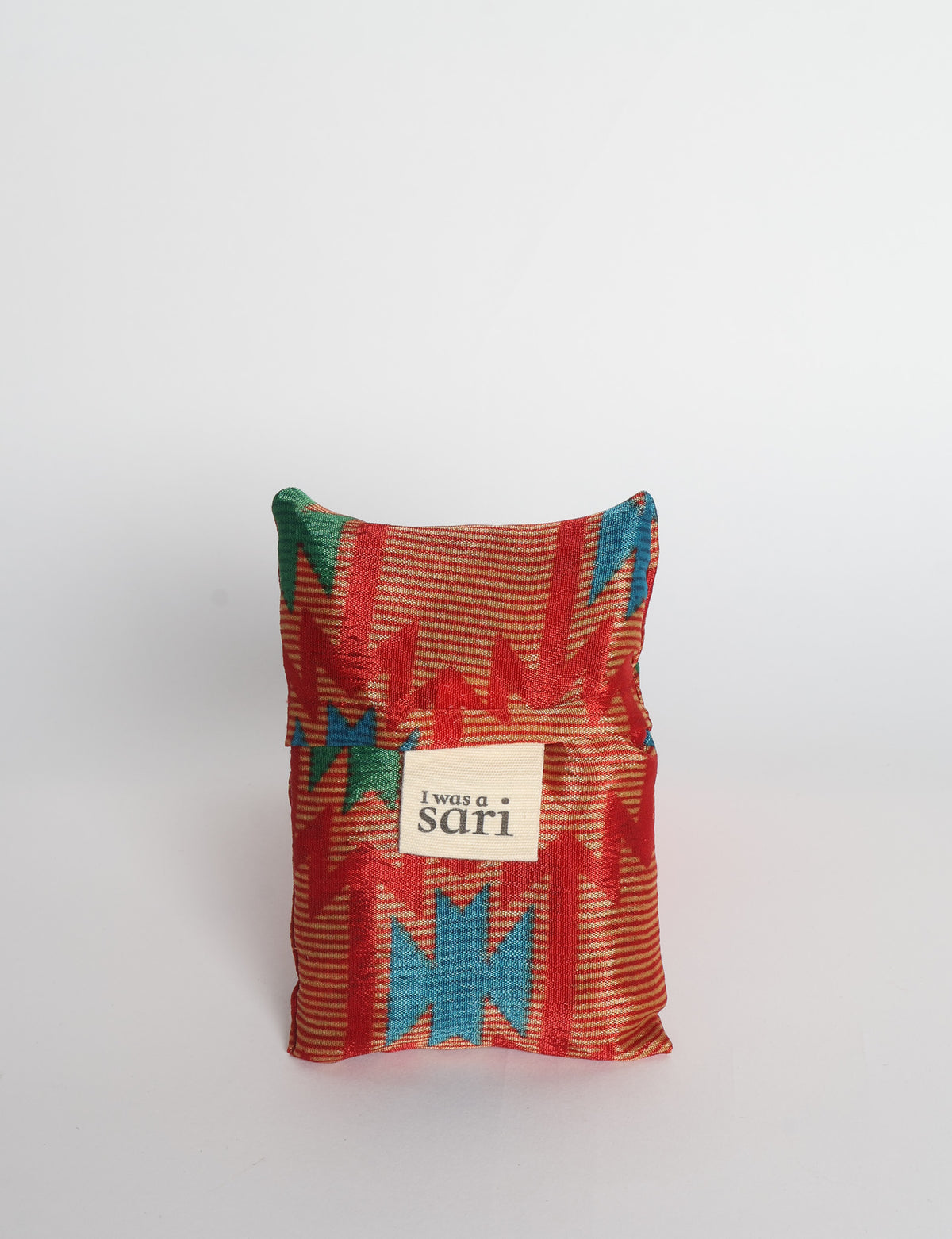 Blue reusable bag with multicolor tropical floral pattern folded with "I was a sari" label visible on front