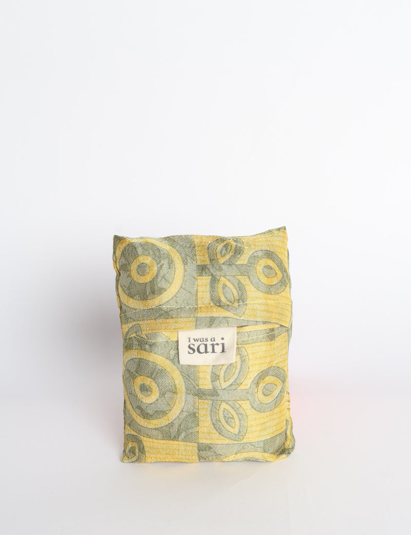 Blue reusable bag with multicolor tropical floral pattern folded with "I was a sari" label visible on front
