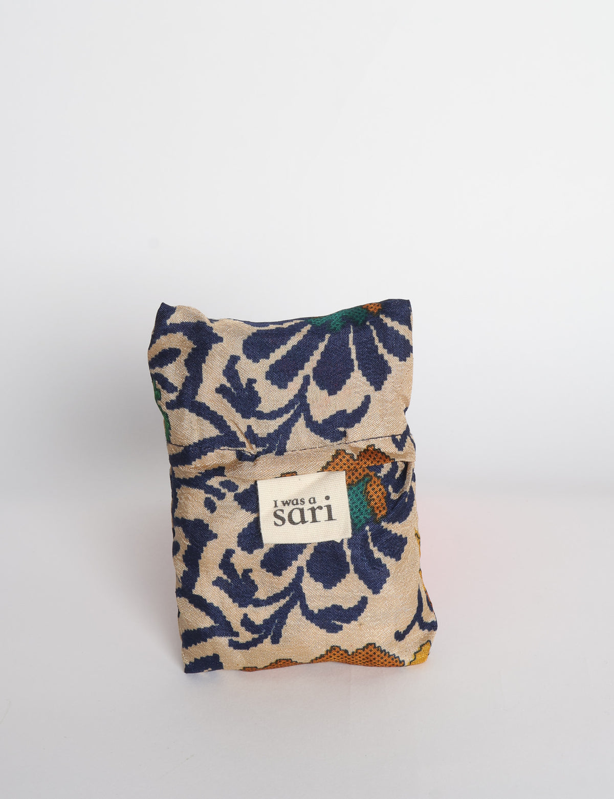 Blue reusable bag with multicolor tropical floral pattern folded with "I was a sari" label visible on front