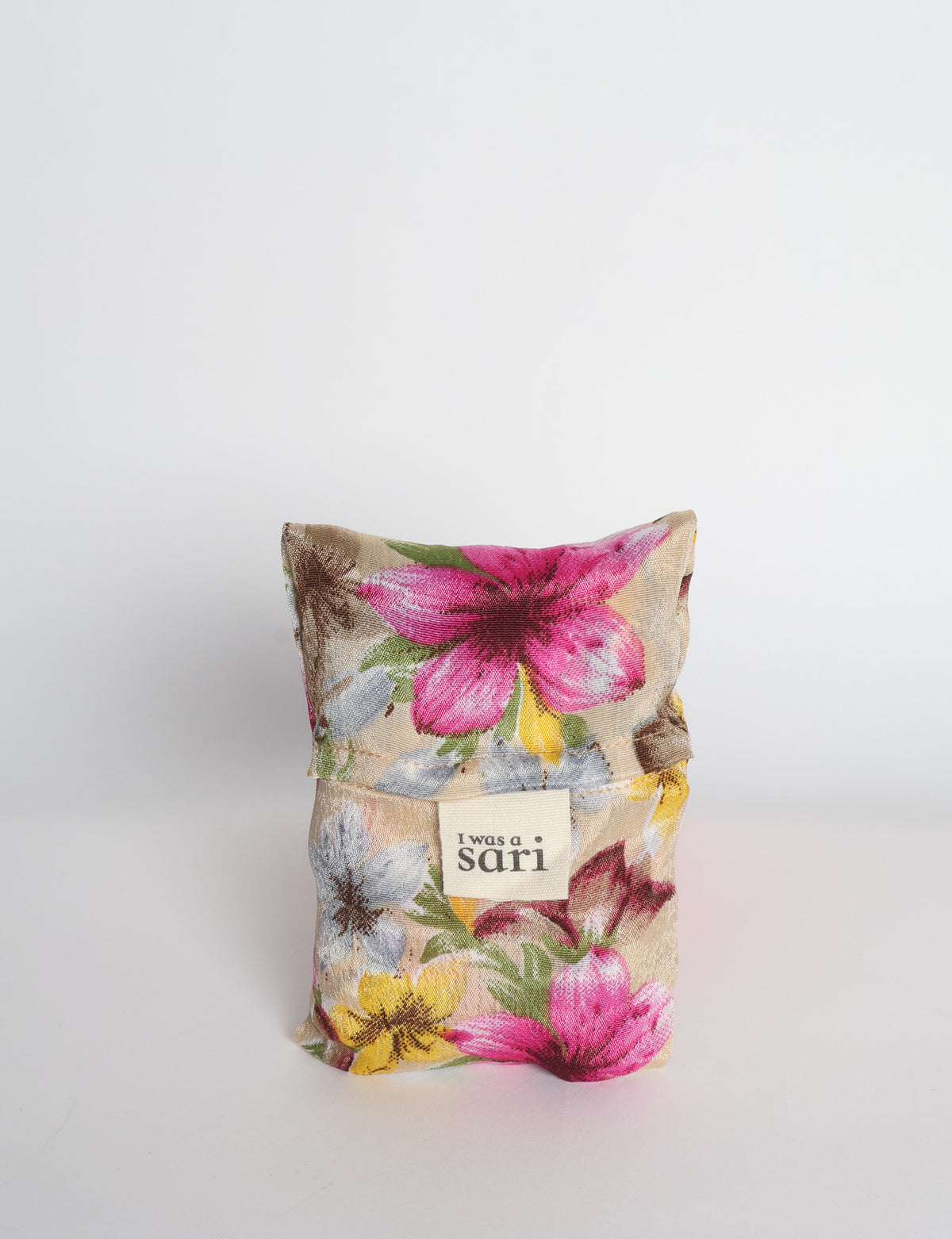 Blue reusable bag with multicolor tropical floral pattern folded with "I was a sari" label visible on front
