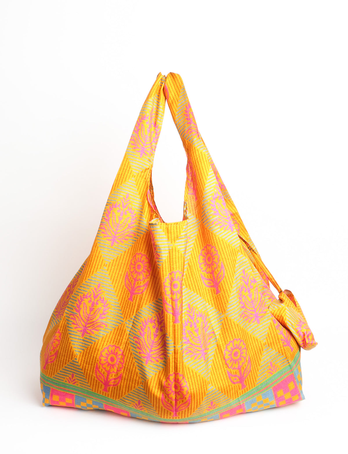 Blue reusable bag with multicolor tropical floral pattern folded with "I was a sari" label visible on front