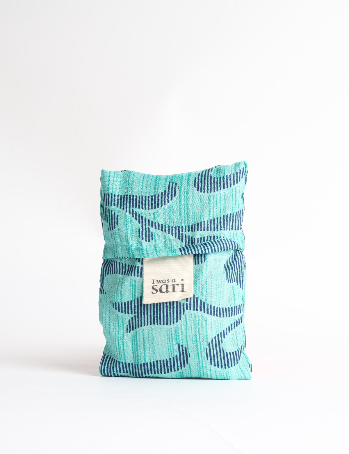 Blue reusable bag with tropical floral pattern in pink, yellow, and green, shown hanging with handles visible