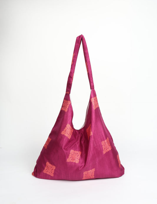 Trapeze bag made from repurposed sari fabric, featuring bold patterns and eco friendly cloth design—part of a sustainable women's clothing collection.