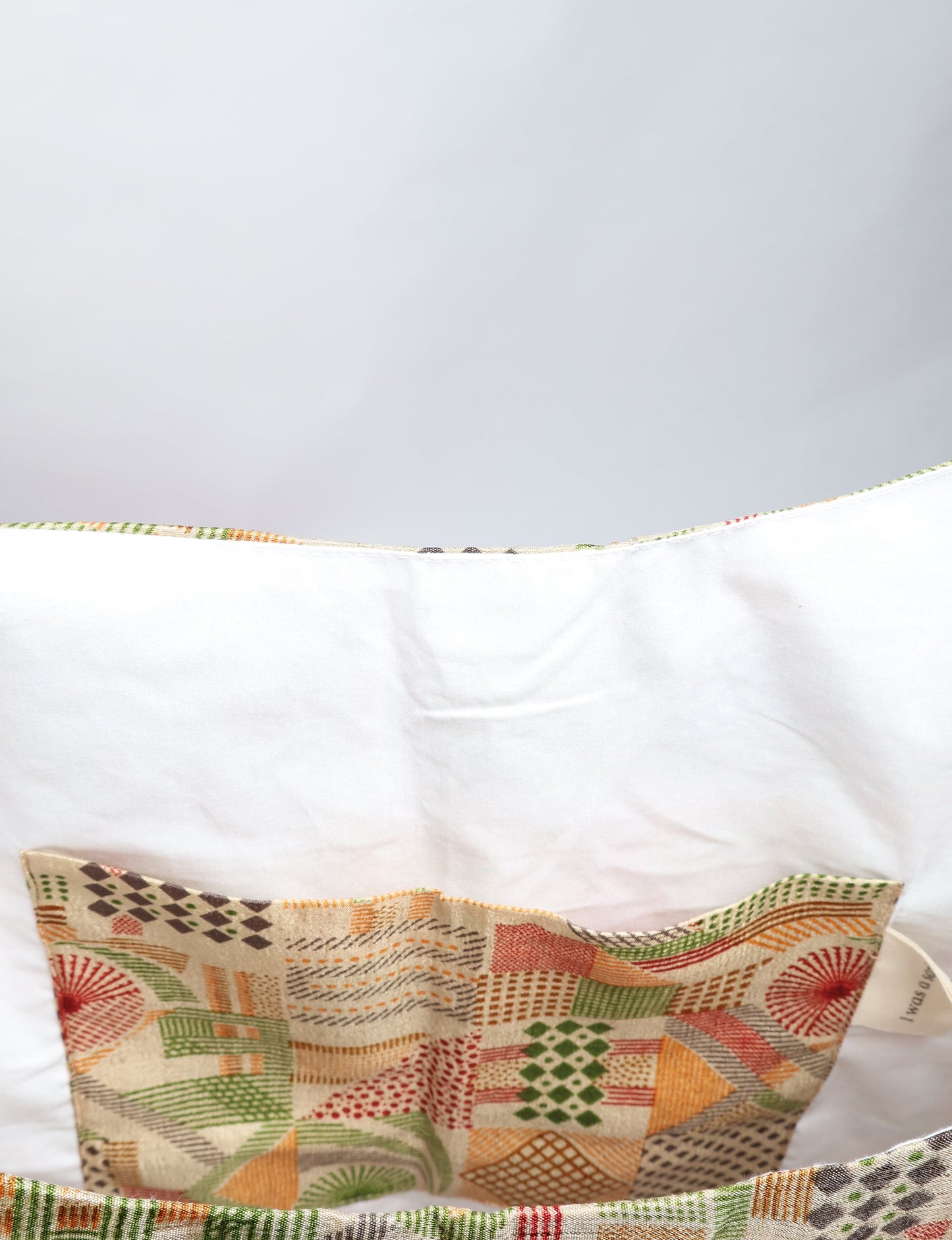 Trapeze bag made from repurposed sari fabric, featuring bold patterns and eco friendly cloth design—part of a sustainable women's clothing collection.