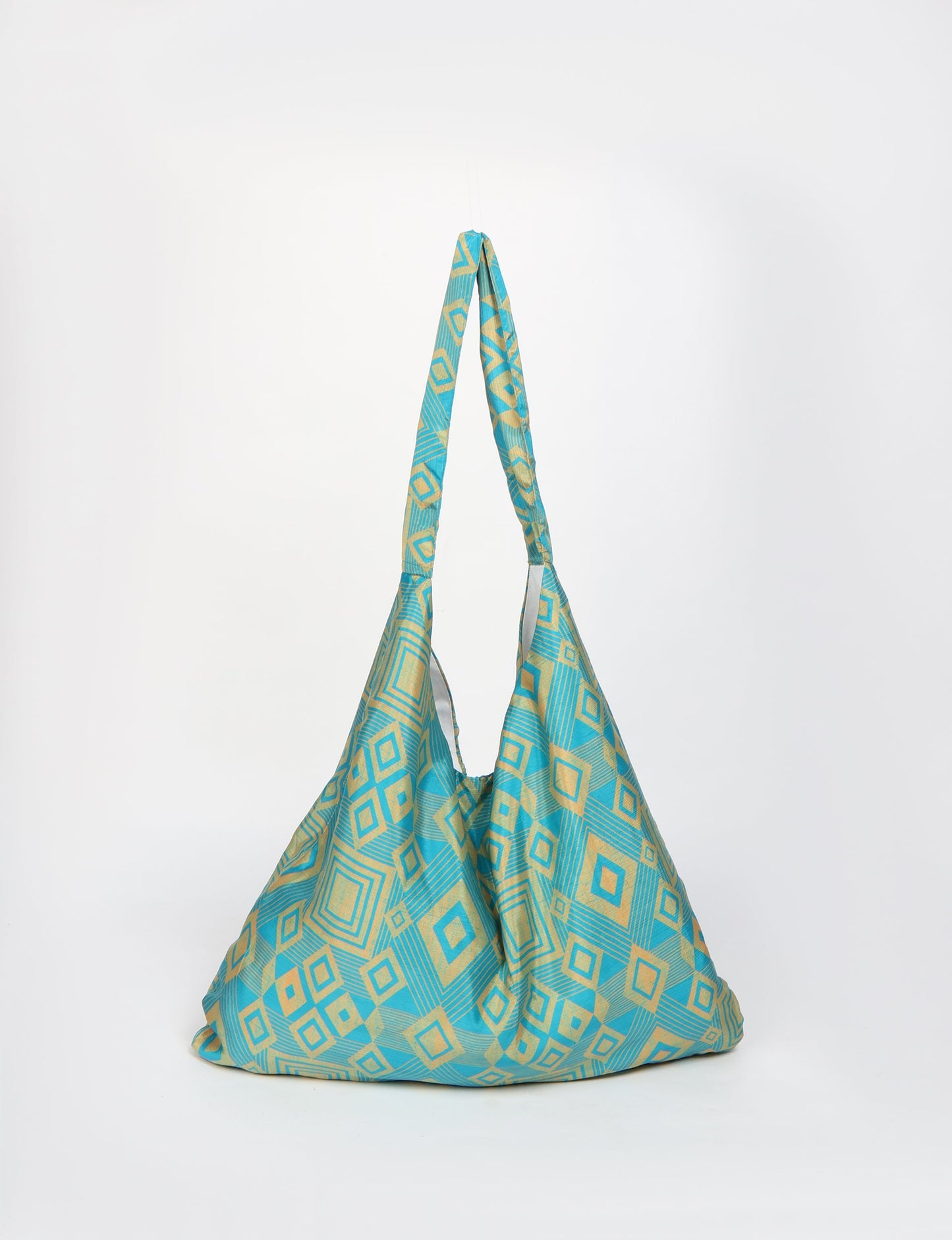 Trapeze bag made from repurposed sari fabric, featuring bold patterns and eco friendly cloth design—part of a sustainable women's clothing collection.