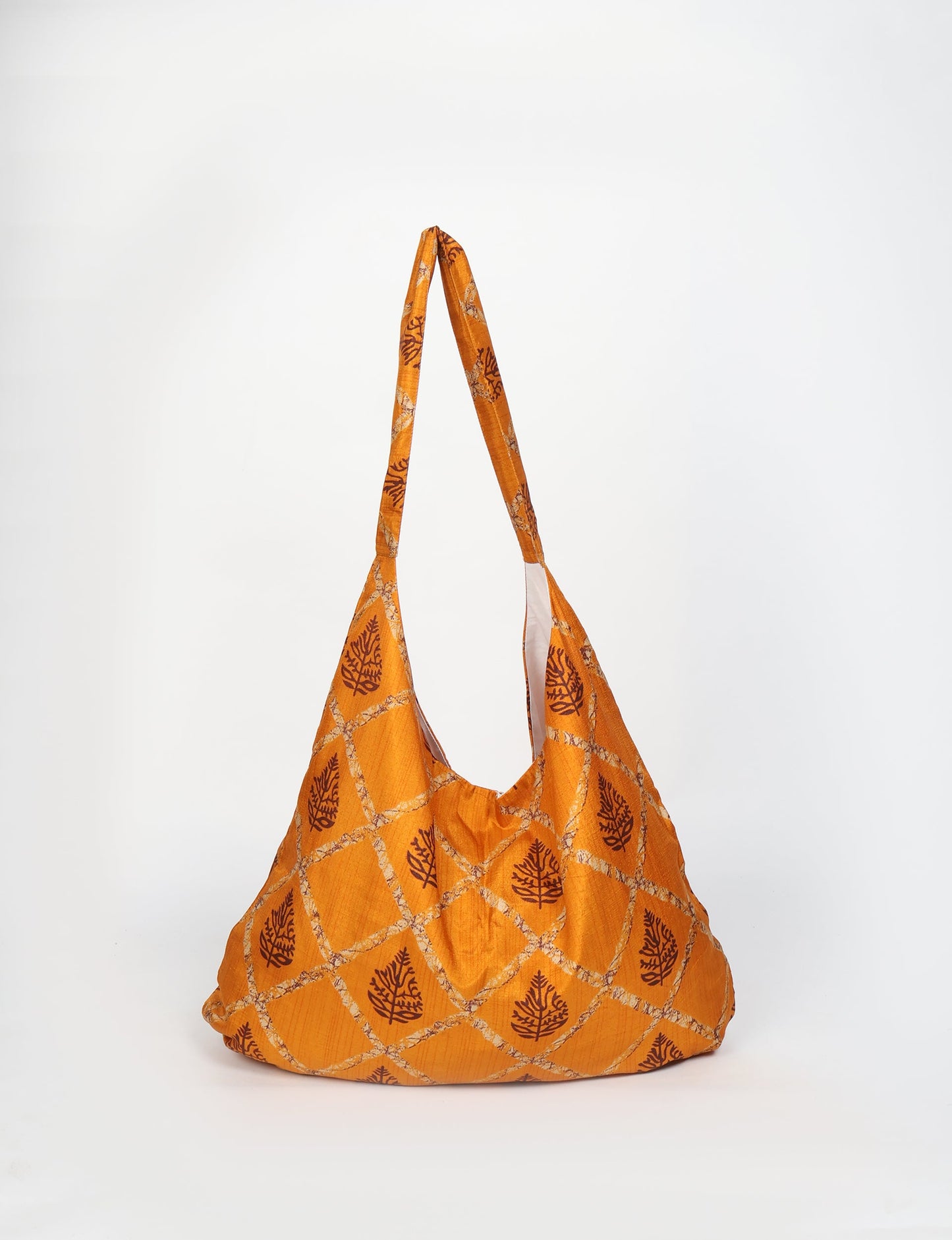 Trapeze bag made from repurposed sari fabric, featuring bold patterns and eco friendly cloth design—part of a sustainable women's clothing collection.