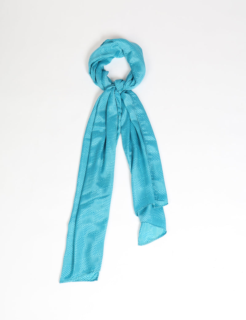 Blue stole with geometric square and dot pattern, shown knotted and hanging against white background