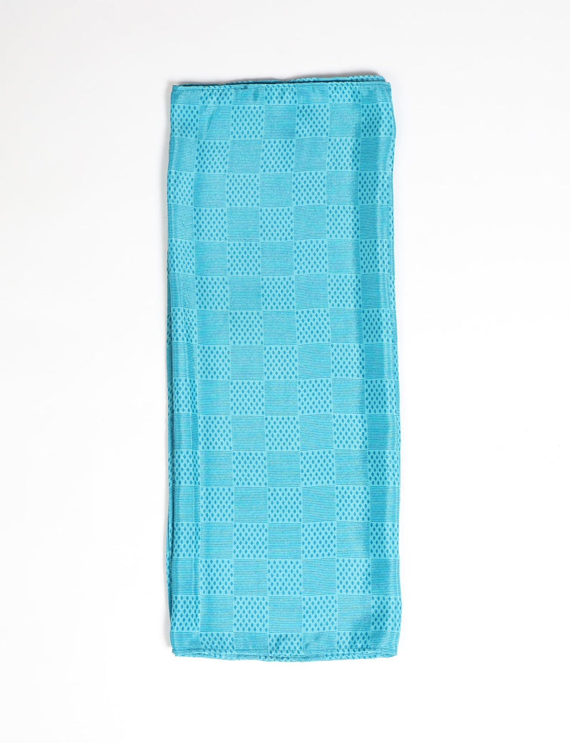 Folded blue stole with alternating geometric square patterns of dots and lines on a white background
