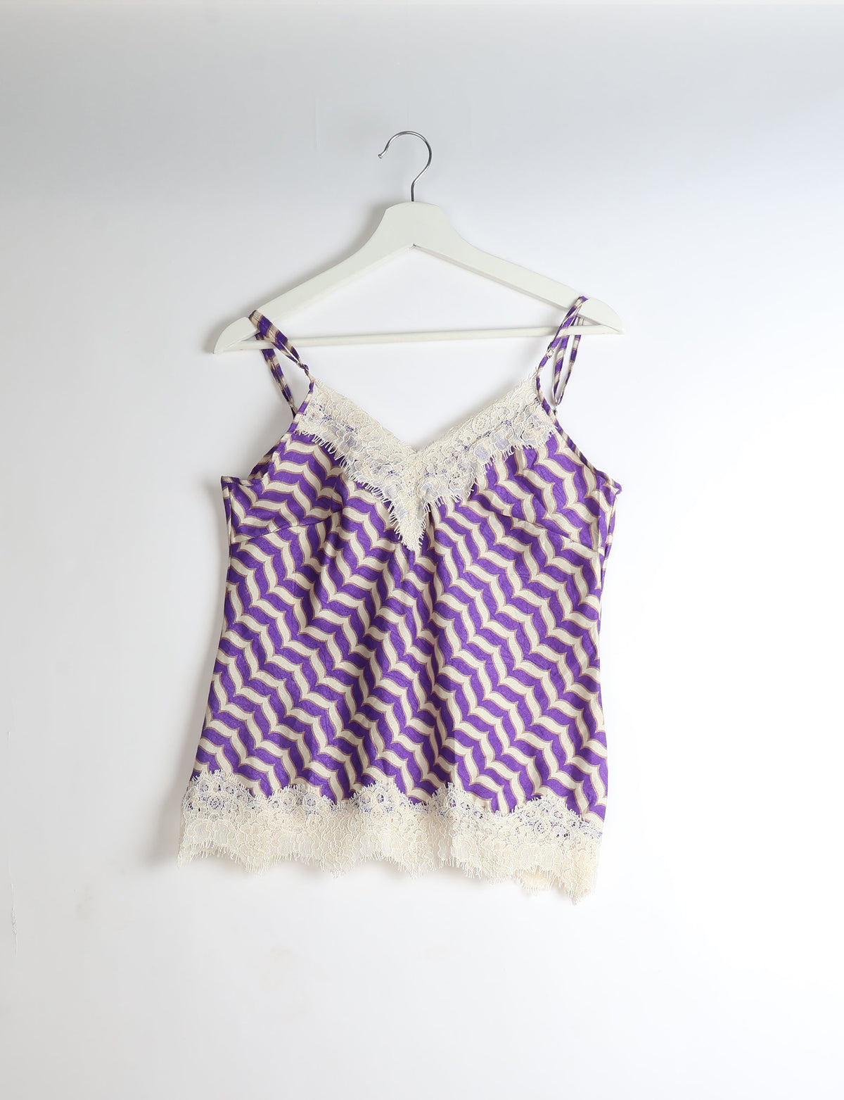 Purple and beige abstract patterned camisole with lace trim on neckline and hem, hanging on white hanger, front view
