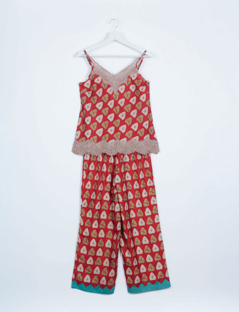 Red floral print pajama set with lace trim on camisole neckline and hem, and teal zigzag detail on pant cuffs, hanging flat