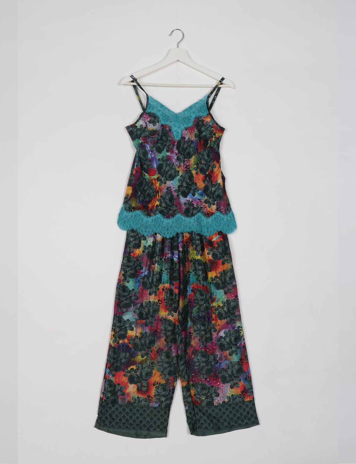 Blue abstract floral print pajama set with lace trim on camisole neckline and hem, shown hanging on white hanger