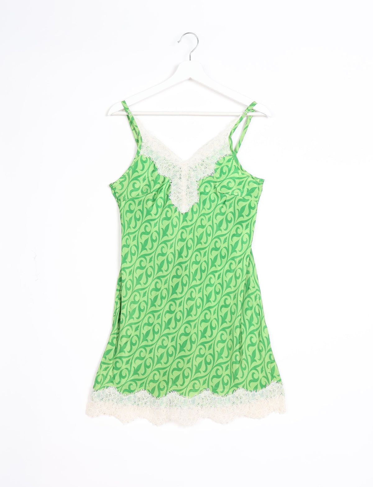 Green night dress with dark green ethnic swirl pattern, white lace trim on V-neckline and hem, hanging on white hanger