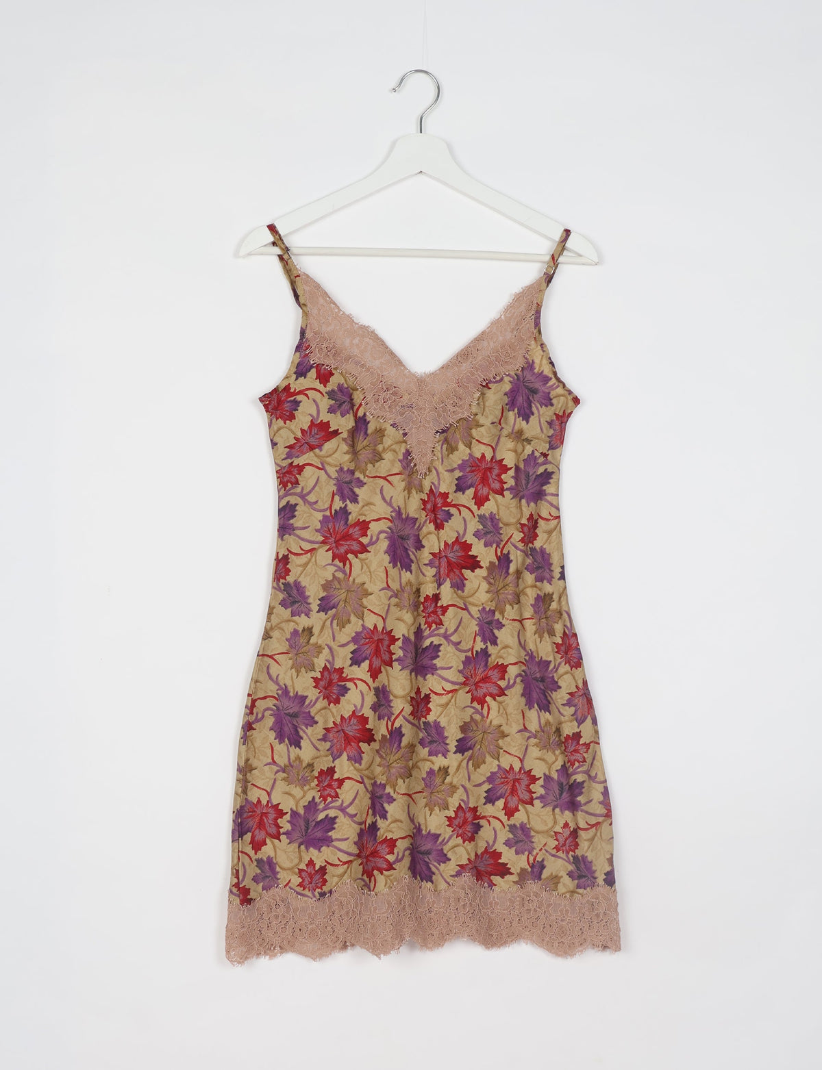 Beige night dress with red and purple leaf pattern, lace trim at neckline and hem, hanging on white hanger