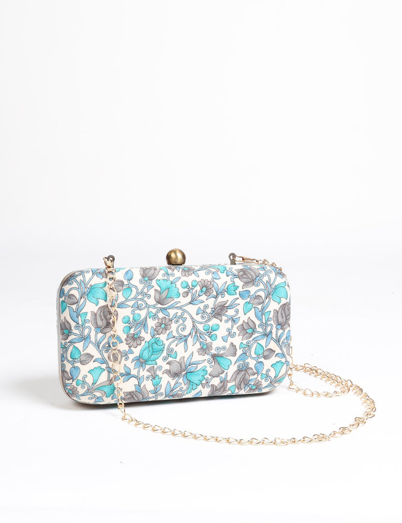 Rectangular clutch handbag with beige background and blue-gray floral pattern, gold-tone clasp and chain strap, front view