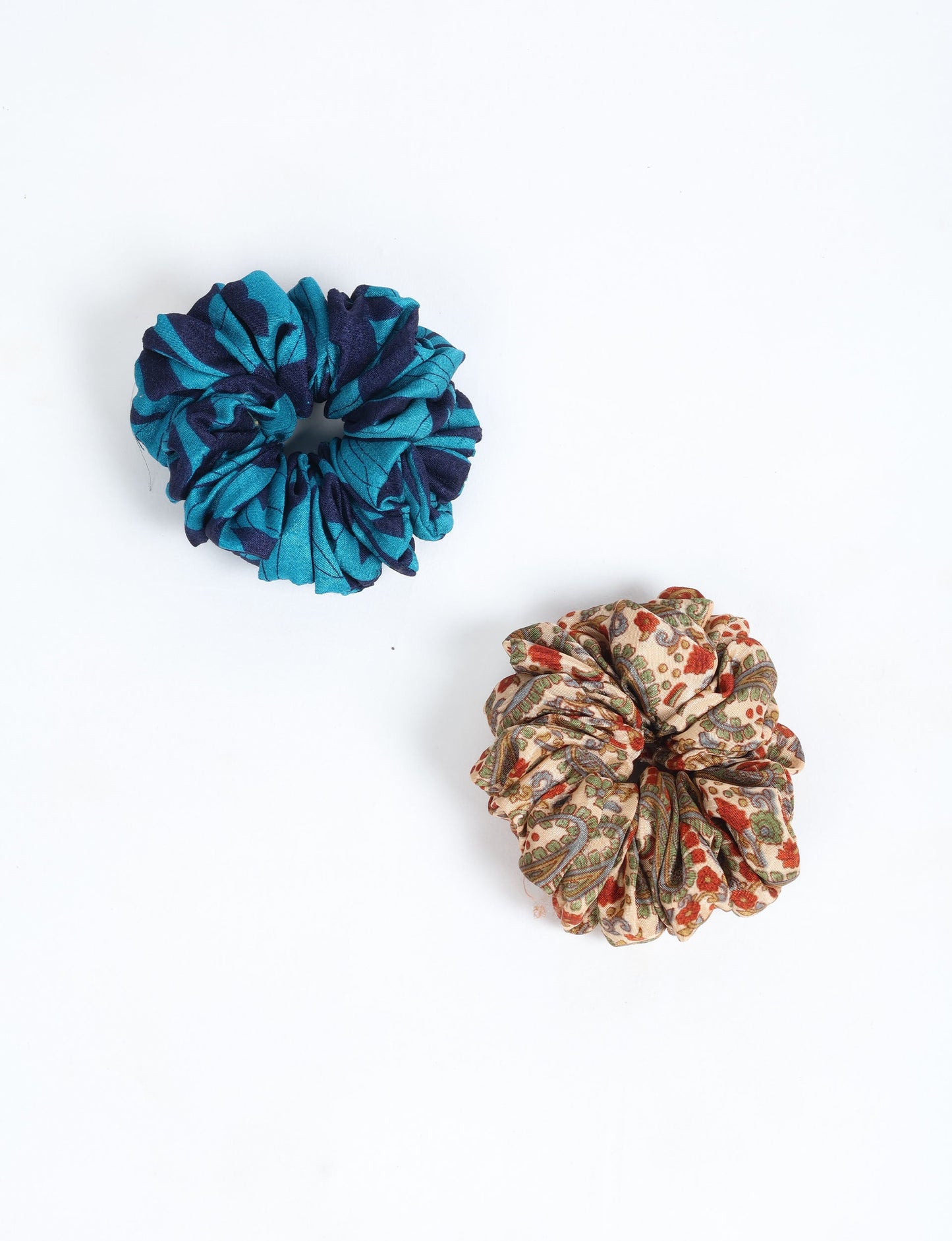 Upgrade your hairstyle with our Scrunchy Set of 2 – elastic hair ties wrapped in colorful Indian sari fabric. A top pick in ethical and green fashion, these eco-friendly prints add flair to your wrist and hair, making a sustainable style statement that catches attention and sparks change.