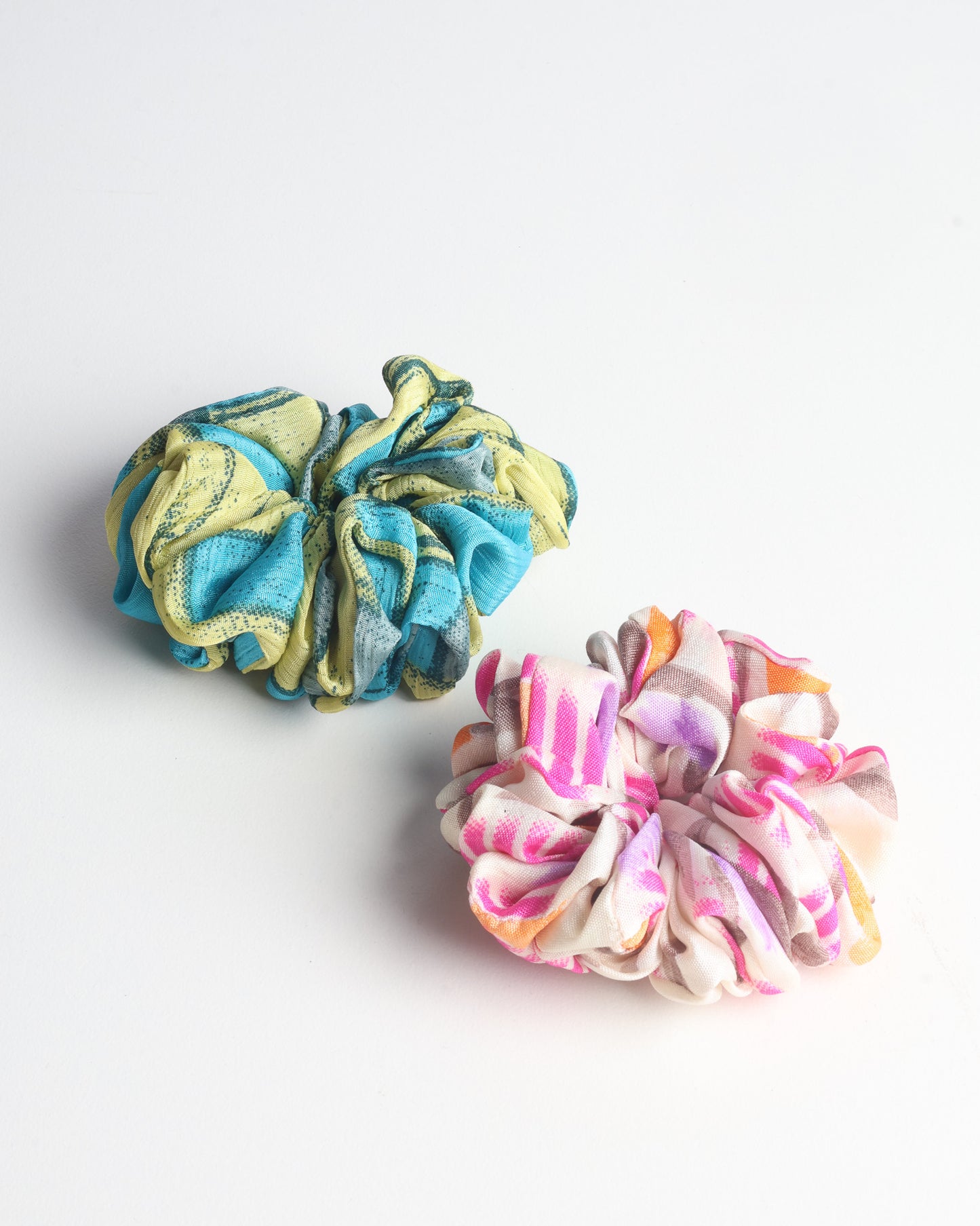 Upgrade your hairstyle with our Scrunchy Set of 2 – elastic hair ties wrapped in colorful Indian sari fabric. A top pick in ethical and green fashion, these eco-friendly prints add flair to your wrist and hair, making a sustainable style statement that catches attention and sparks change.
