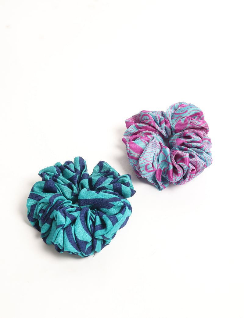 Set of two fabric scrunchies, one teal and navy striped, one pink and light blue patterned, shown flat on white background