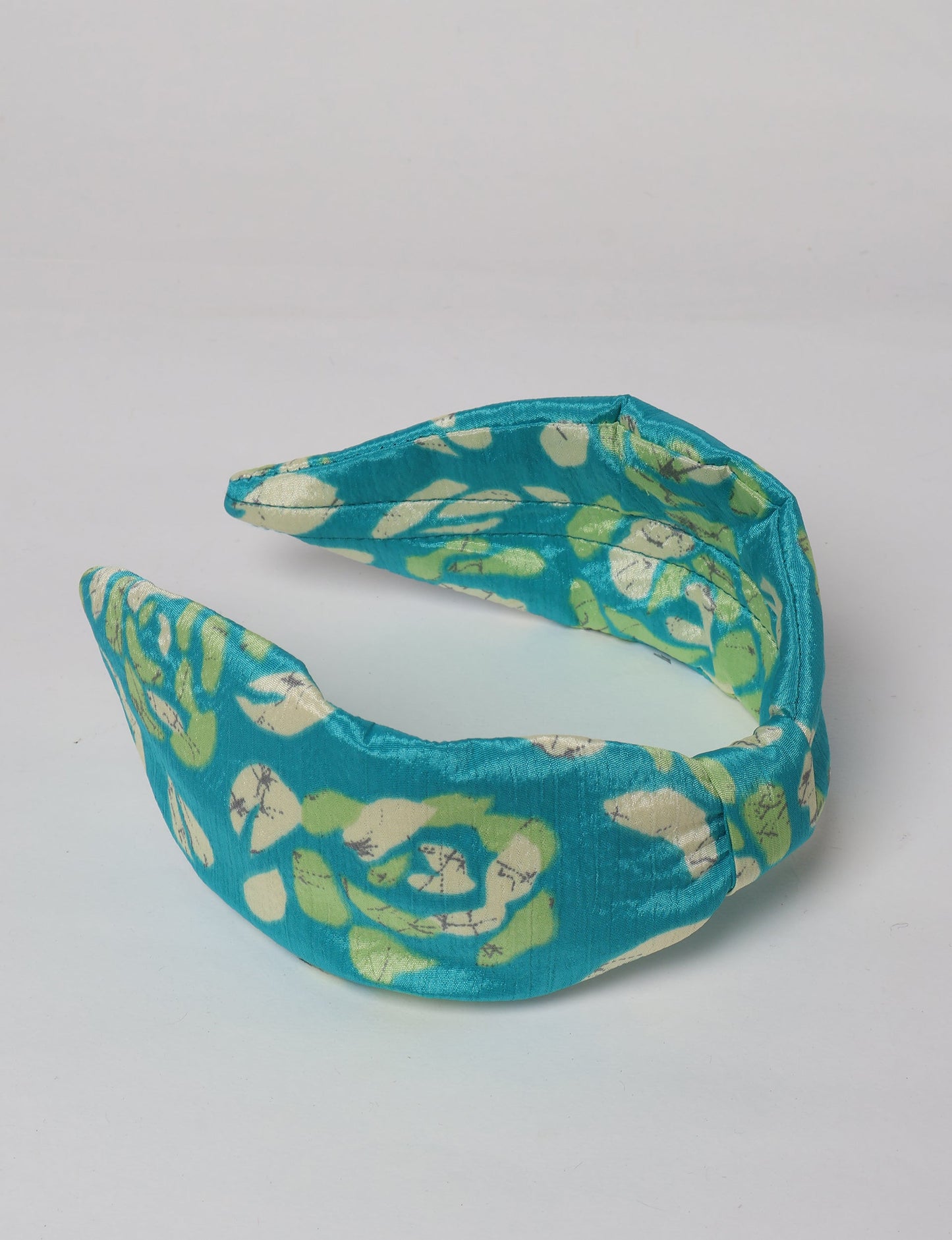Upcycled sari hairband with central knot, handmade in India — an eco friendly fashion accessory representing green fashion, upcycled women’s clothing, fair trade fashion, and earth friendly clothing made from recycled sari textiles.