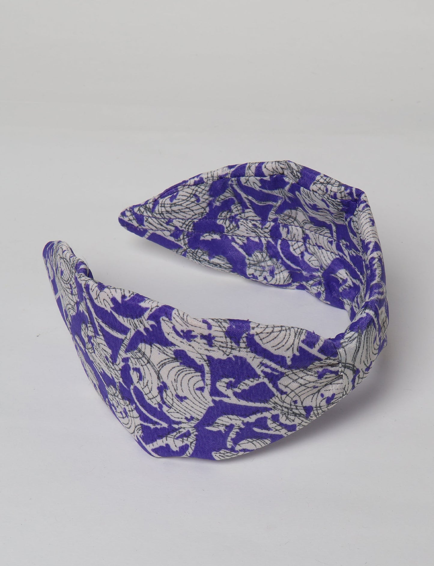 Upcycled sari hairband with central knot, handmade in India — an eco friendly fashion accessory representing green fashion, upcycled women’s clothing, fair trade fashion, and earth friendly clothing made from recycled sari textiles.