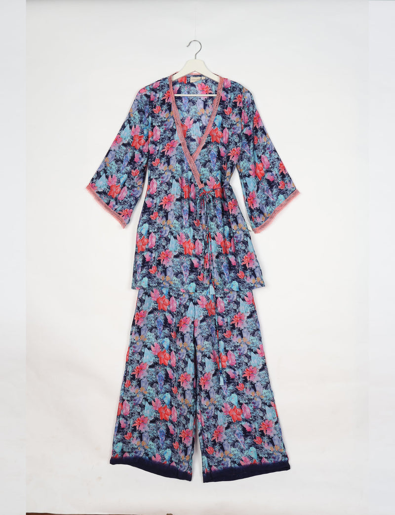 Blue floral print tunic set with pink lace trim on V-neck and sleeves, hanging on white hanger against white background
