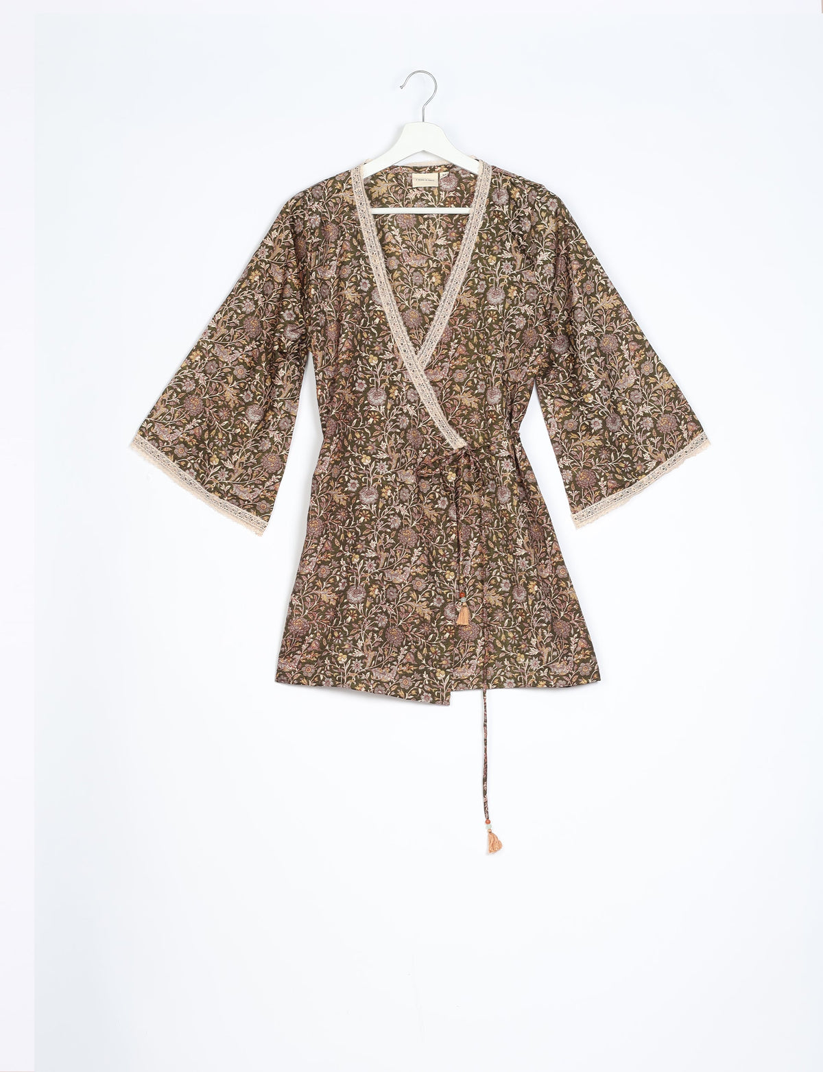 Brown tropical print tunic with V-neck, lace trim, wide sleeves, and waist tie, hanging on a white hanger