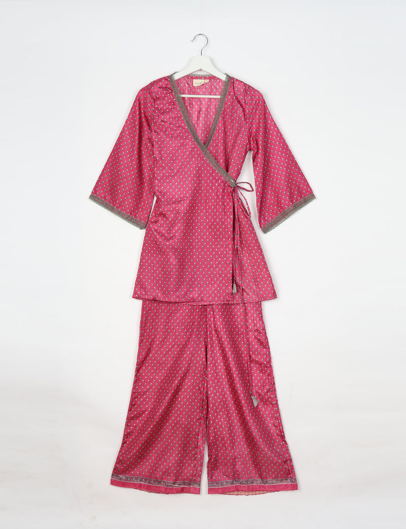 Pink tunic set with micro floral print, wrap top with tie closure and wide-leg pants, hanging on white hanger