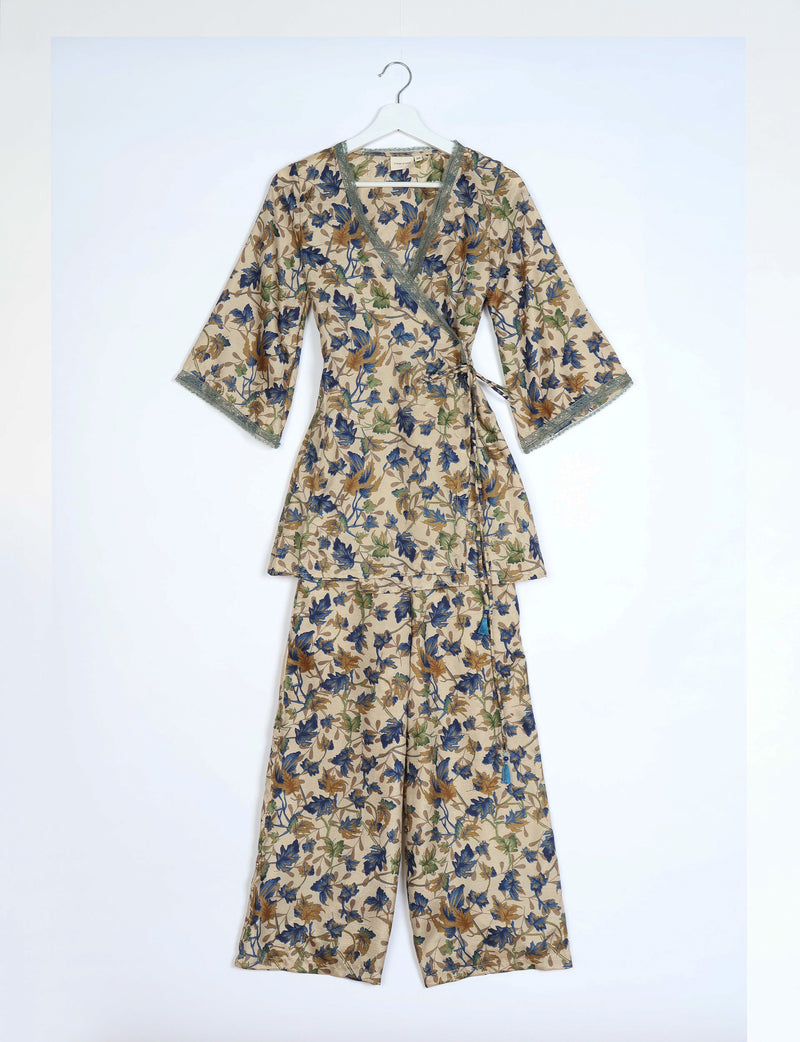Beige tunic set with blue, green, and brown leaf print, wrap top with lace trim, and matching wide-leg pants on hanger