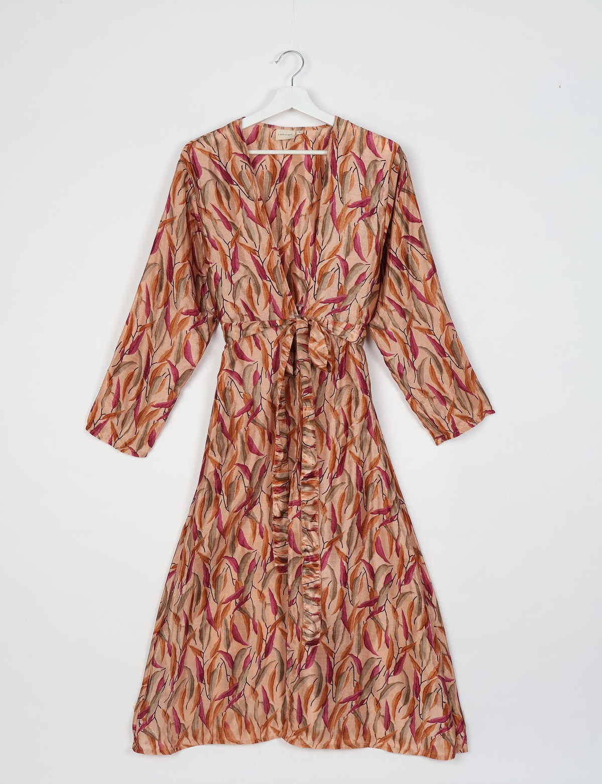 Beige beach robe with long sleeves and a multicolor leaf pattern, front tie belt, hanging on white hanger