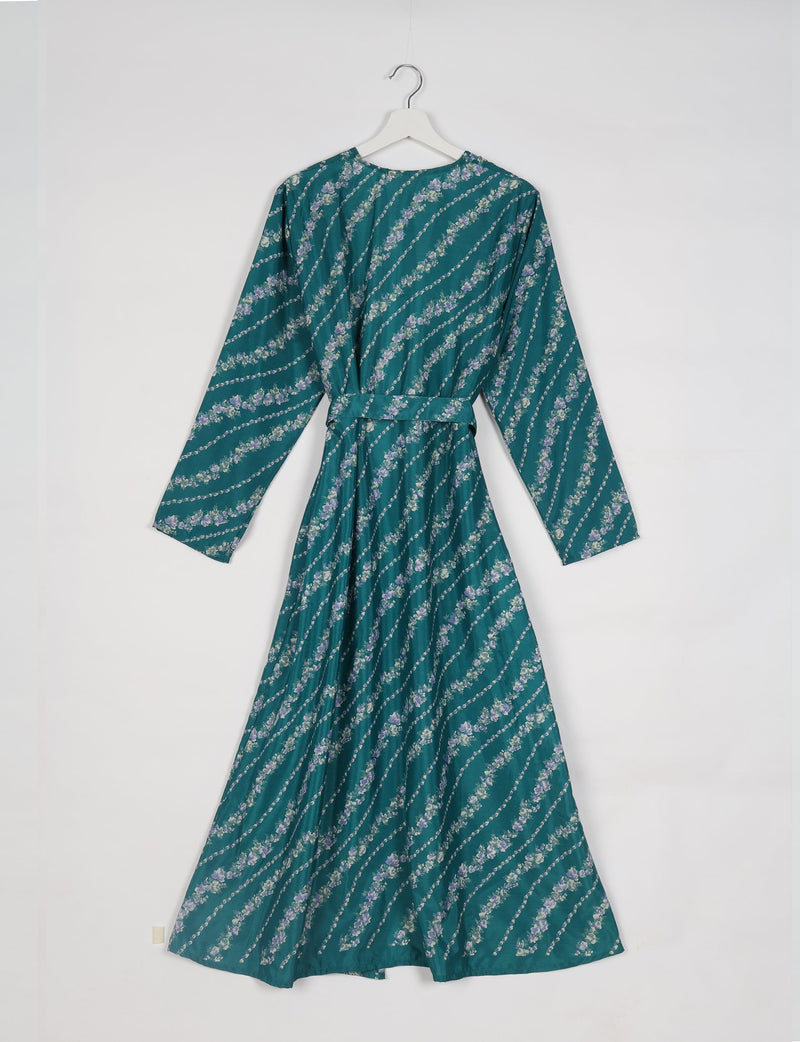 Blue-green long-sleeve beach robe with diagonal floral stripes, belt at waist, shown hanging on white hanger, back view