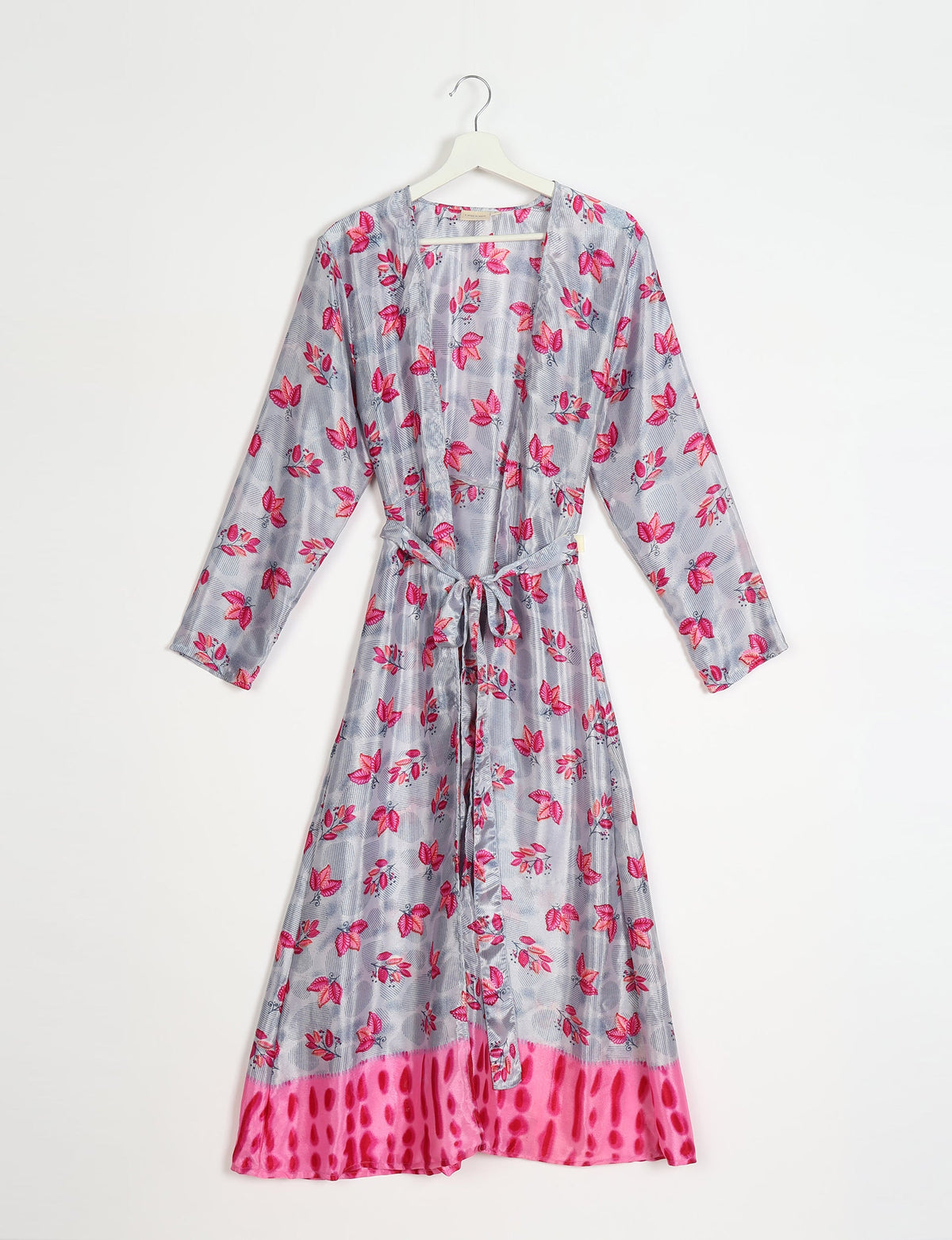 Long-sleeve beach robe with pink leaf print on gray background and bright pink patterned hem, hanging on white hanger