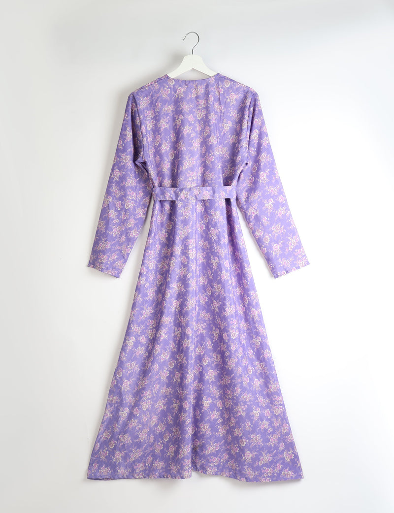 Purple floral long-sleeve beach robe with belt, shown from back, hanging on white hanger against white background