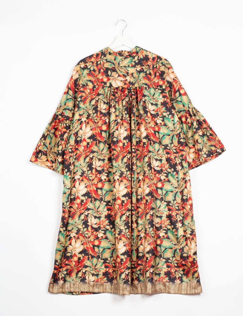 Black floral bell sleeve coat with red, green, and beige leaves, gathered back yoke, and beige hem, hanging on white hanger