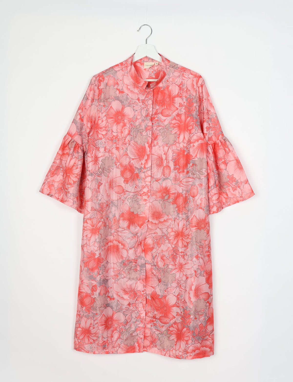 Pink floral bell sleeve coat with stand collar, front button closure, shown hanging on white hanger front view