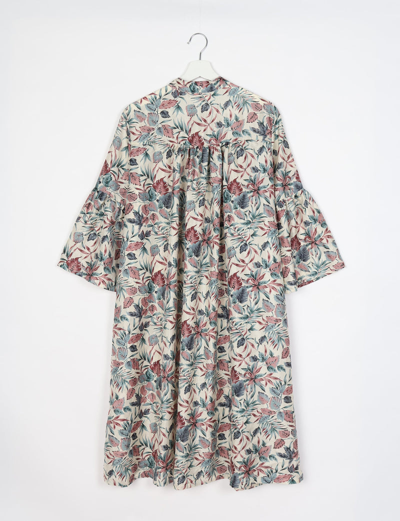 White bell sleeve coat with red, blue, and gray leaf print, shown from back on white hanger against white background