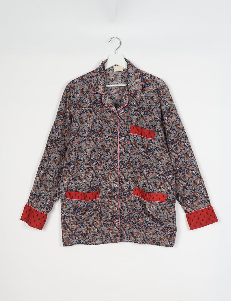 Long-sleeve grey tropical print pajama top with red cuffs and pocket accents, button front, and pink piping on hanger