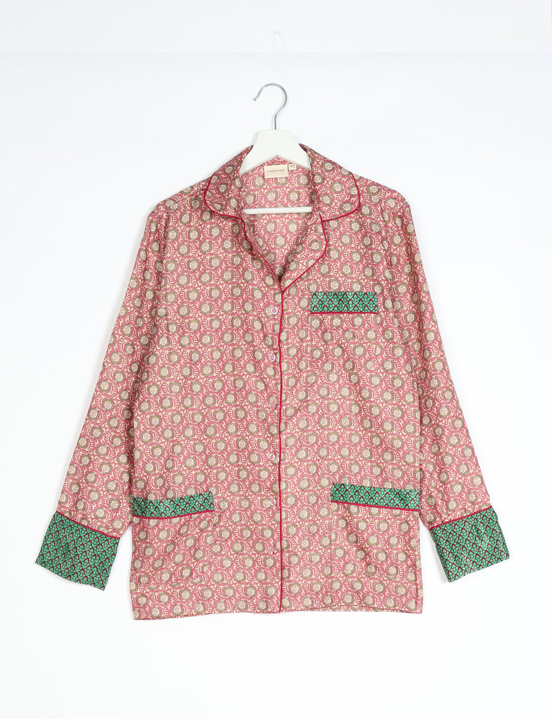 Long-sleeve pink pajama top with beige floral micro design, green patterned cuffs and pocket trim, hanging on white hanger