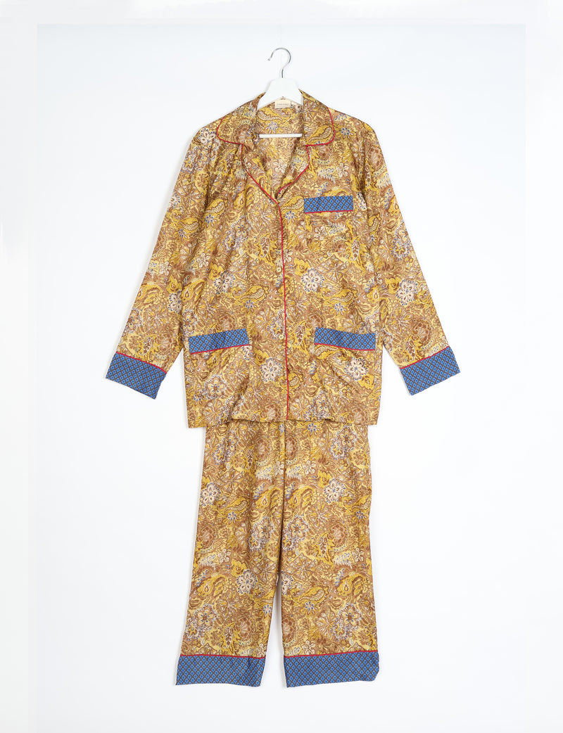 Yellow tropical long-sleeve pajama set with blue patterned cuffs and pockets, hanging flat on a white background