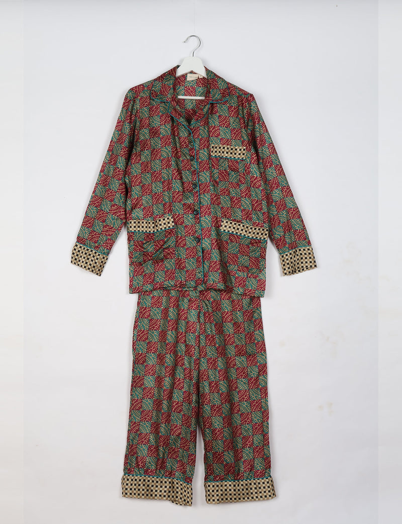 Red tropical print long sleeve pajama set with checkered cuffs, pocket trim, and button front, hanging on white hanger