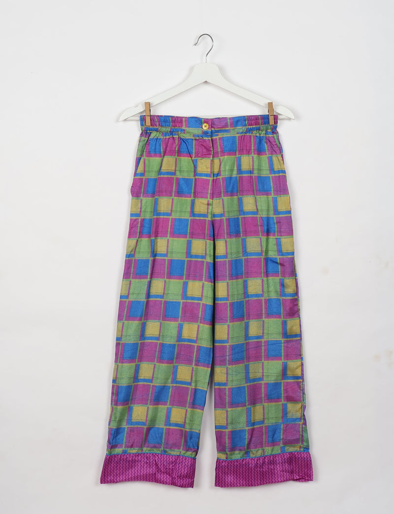 Pink geometric patterned pajama pants with elastic waistband and button, shown flat on hanger