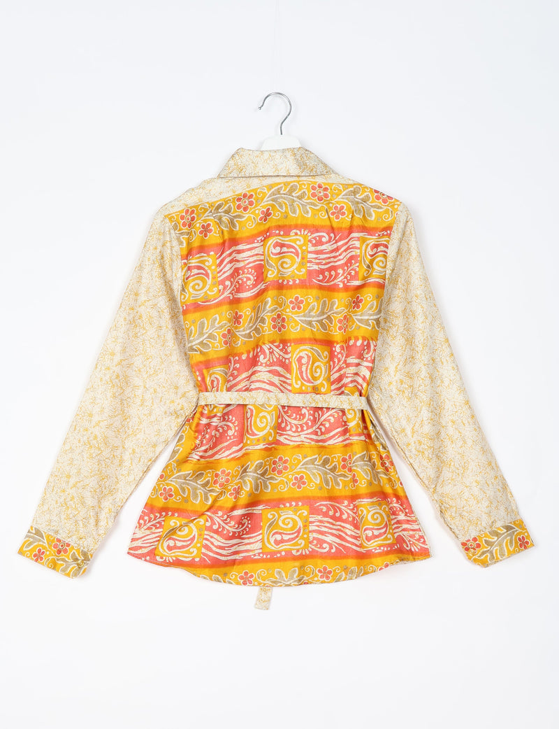 White shirt with yellow and orange tropical floral and swirl patterns, long sleeves, and a belt, shown from back on hanger