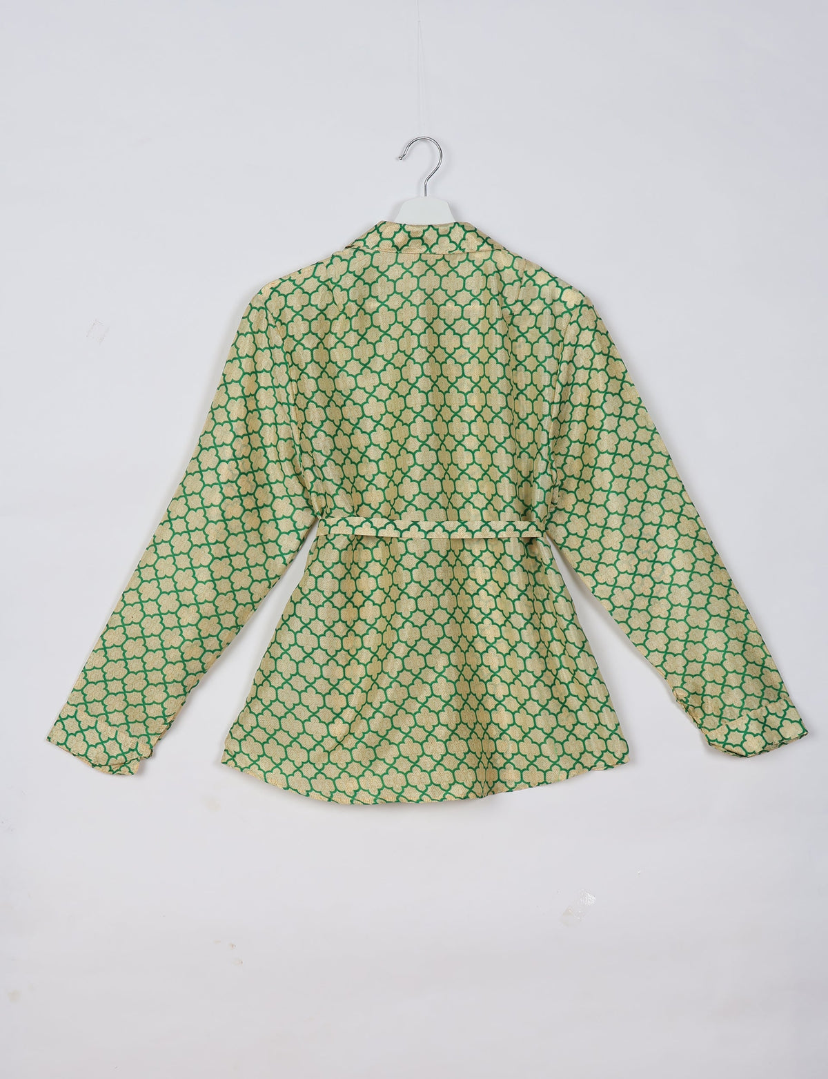 Long-sleeve shirt with green and beige geometric floral pattern, back view, hanging on white hanger against white background