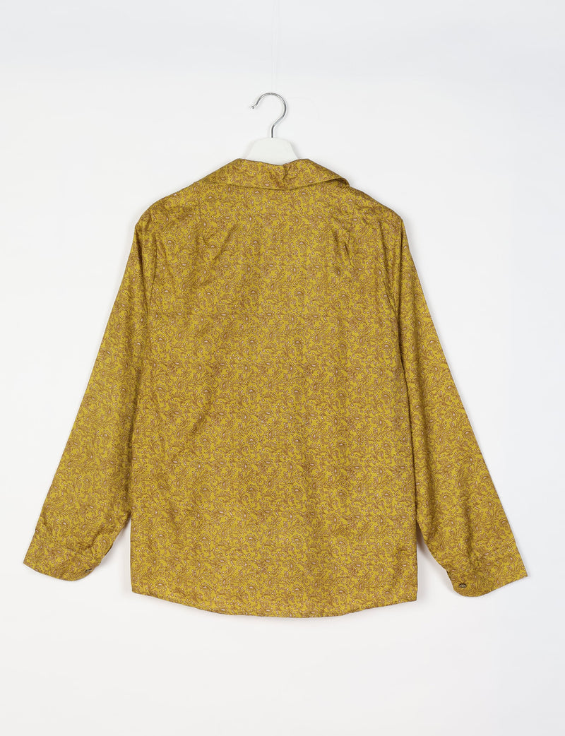 Yellow long-sleeve shirt with brown floral paisley pattern, shown from back, hanging on white hanger against white background