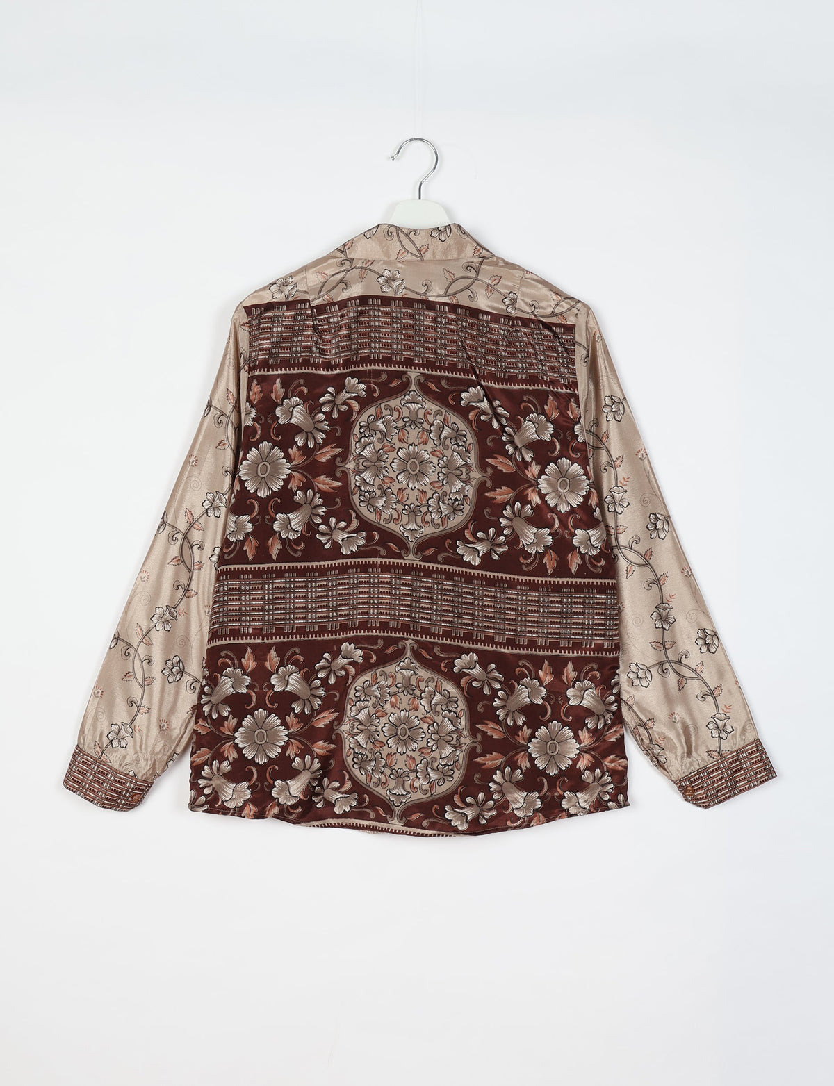 Beige and brown floral patterned long-sleeve shirt with buttoned cuffs hanging on white hanger, back view