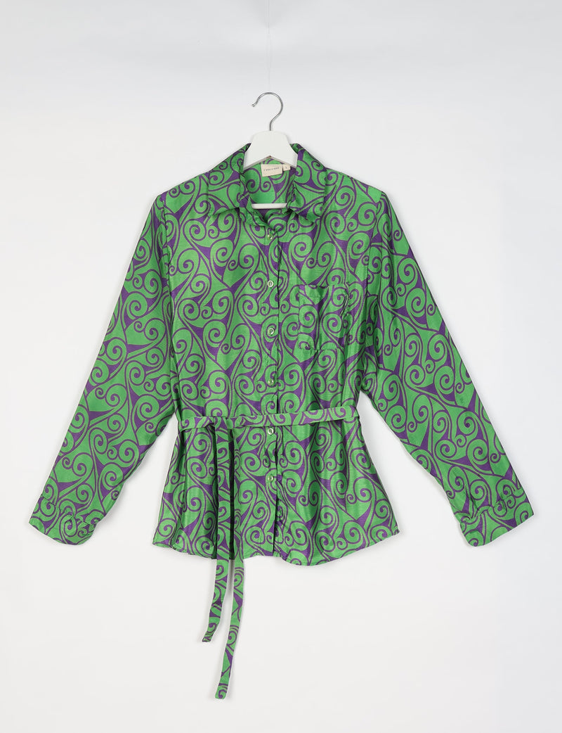 Green button-up shirt with purple abstract swirl pattern, long sleeves, chest pocket, and waist tie belt, front view on hanger