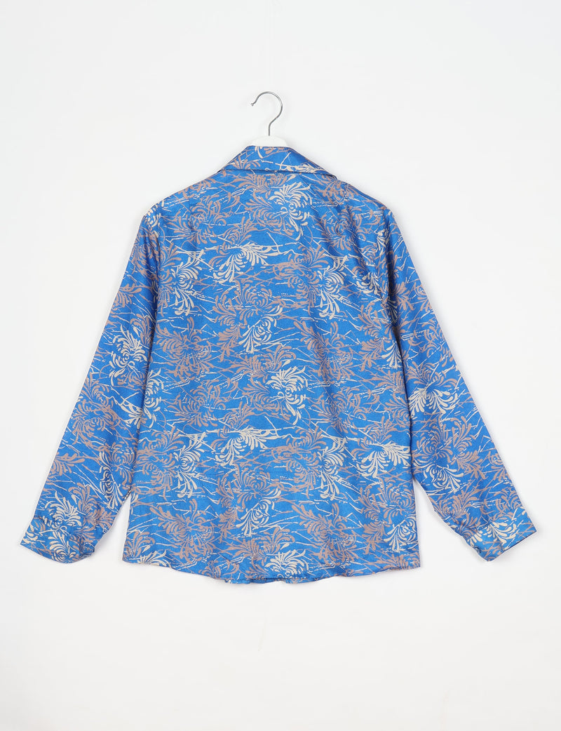 Blue long-sleeve shirt with beige and white abstract floral pattern, shown from back on white hanger against white background