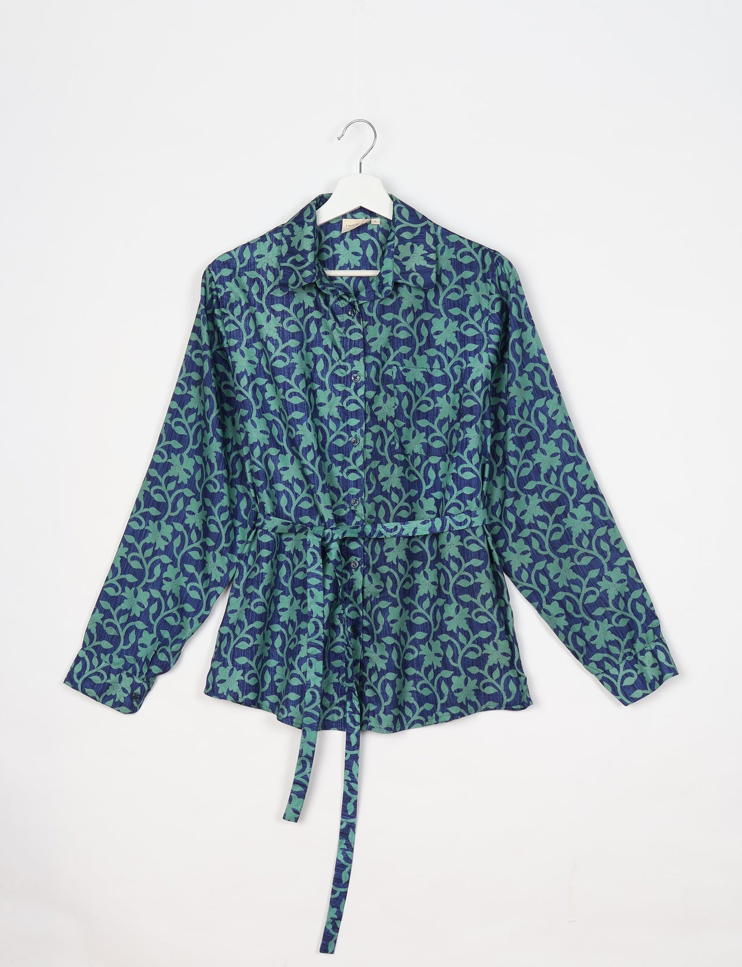 Experience sustainable fashion with our classic slim-fit shirt, crafted with ethical and green values. The shirt, designed for minimal waste, features a tie-up waist belt or neck tie, semi-spread collar, and regular shirt cuffs. Versatile and eco-friendly, wear it tucked in, unbuttoned over a tank top, or knotted at the waist for a unique style.