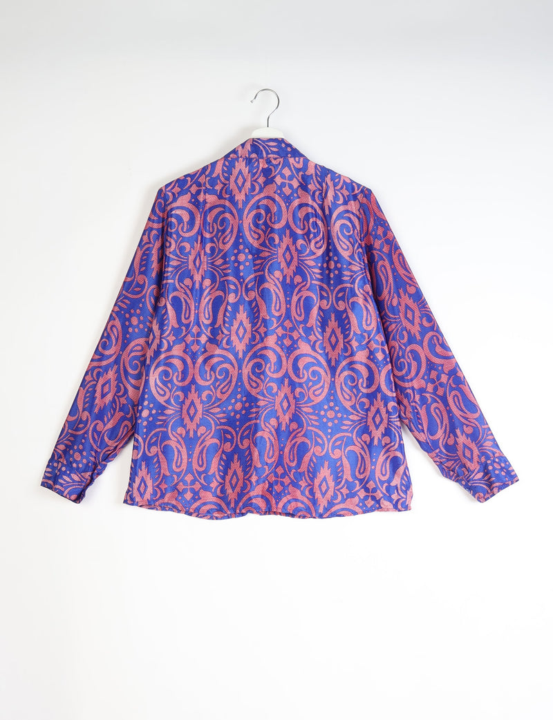 Blue shirt with pink paisley pattern, long sleeves, and buttoned cuffs, shown from back on a hanger